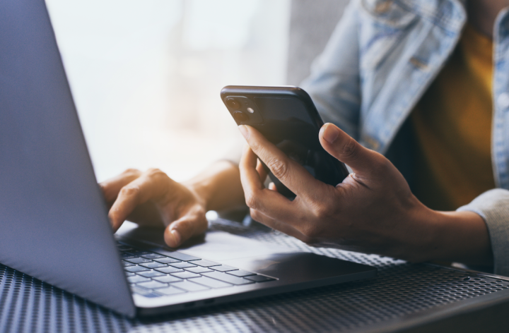image of a person using laptop and mobile